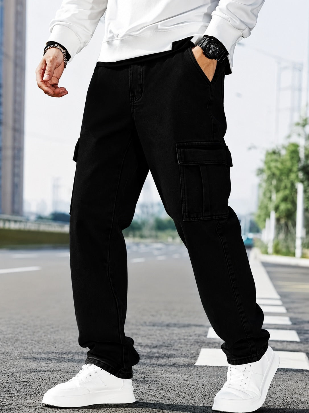 Men’s black cargo jeans with multiple utility pockets, relaxed fit, and stylish streetwear design, paired with a white sweatshirt and sneakers.